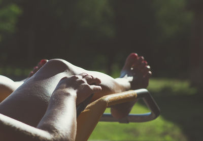 Low section of woman relaxing on deck chair in back yard