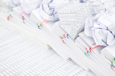 High angle view of crumpled paper balls and model house on financial documents