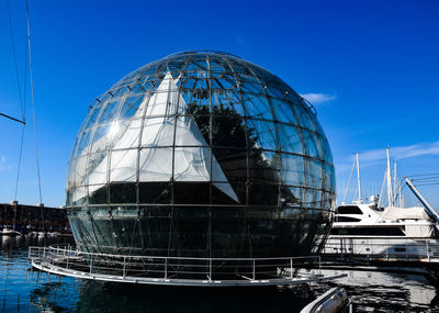 Reflection of building in water against clear blue sky