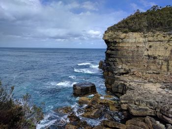 Rock formation on beach against sky