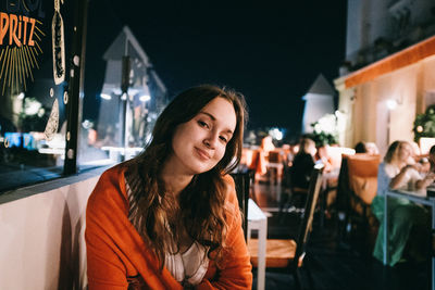 Portrait of smiling young woman at night