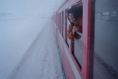 Rear view of woman standing on window