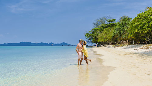 Rear view of woman walking at beach