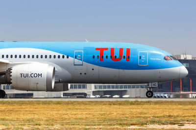 Airplane on airport runway against clear sky