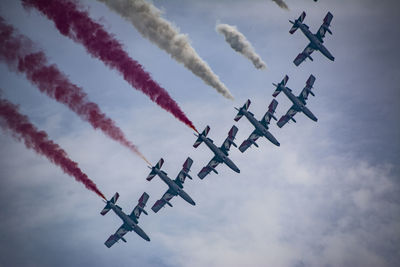 Low angle view of airplanes flying against sky