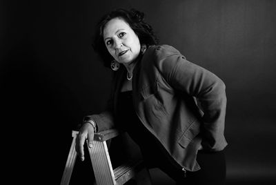 Young woman standing against black background