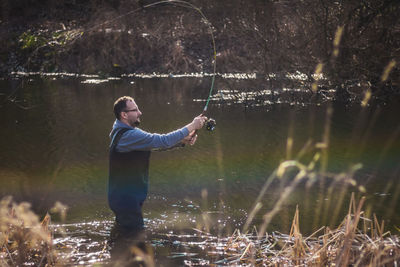 Full length of man fishing in lake