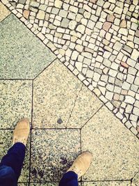 Low section of person standing on tiled floor