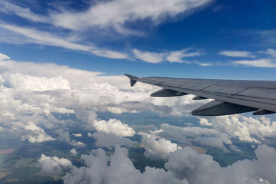 The plane is flying in the clouds, the wing of the plane