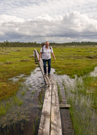 Full length of man standing on shore against sky