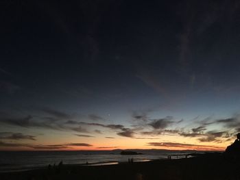 Scenic view of beach against dramatic sky