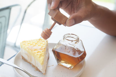 Midsection of person holding ice cream on table