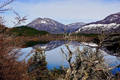 Idyllic view of calm lake and mountains against sky