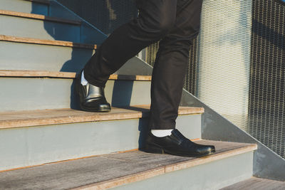 Low section of man standing on staircase