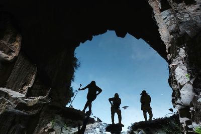 Low angle view of silhouette men against sky