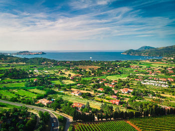 Aerial view of townscape by sea against sky