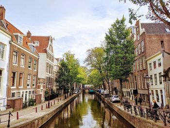 Canal amidst buildings against sky