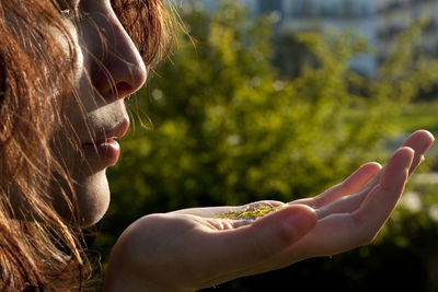 Close-up of woman with leaves on palm