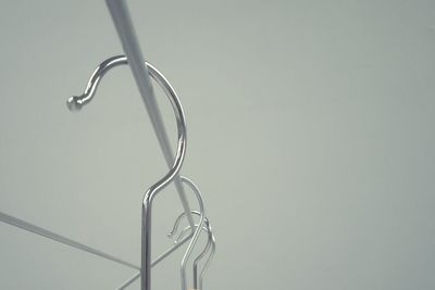 Cropped image of coathangers against white wall
