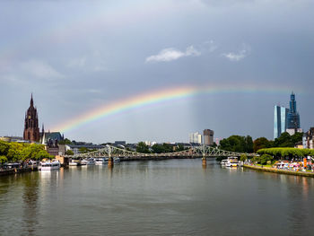 Rainbow over river with buildings in background