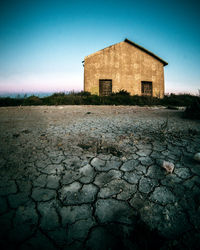 Exterior of old house on field against sky