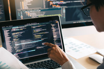 Man coding in laptop at office