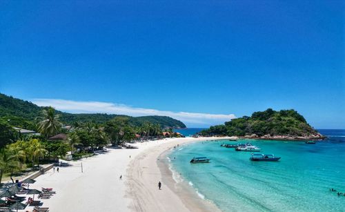 Scenic view of beach against clear blue sky