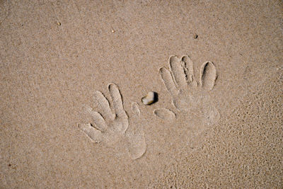 High angle view of handprints on sand