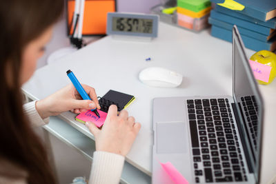 Midsection of woman using laptop on table