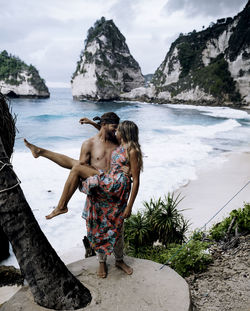 A couple at the famous diamond beach of nusa penida / bali.