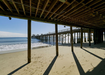 Pier on beach against sky