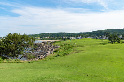 Scenic view of golf course against sky