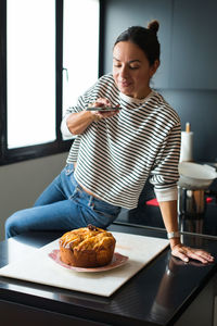 Portrait of young woman sitting on table