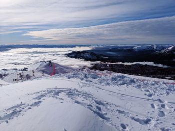 Snow covered landscape against sky