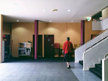 Rear view of woman standing in corridor