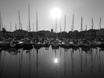 Sailboats moored at harbor against sky