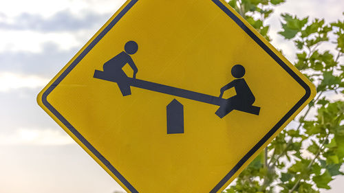 Low angle view of road sign against sky