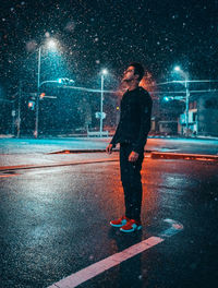 Full length of man standing on illuminated road