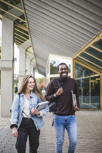 Happy male and female students at university