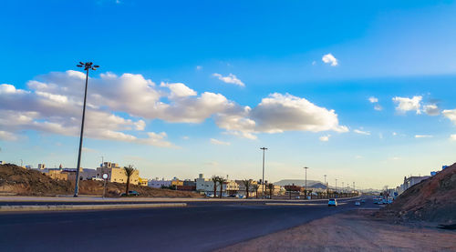 Road by street against blue sky