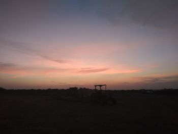 Scenic view of silhouette field against sky during sunset