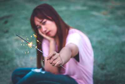 Portrait of woman holding cigarette against blurred background
