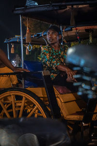 Midsection of man sitting in bus at night
