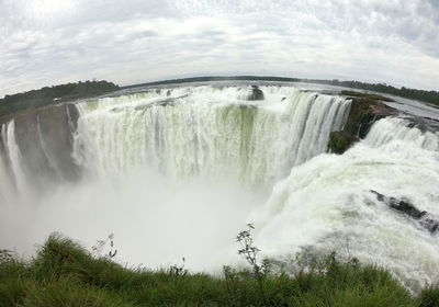 Scenic view of waterfall against sea