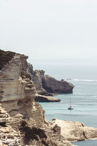 Lonesome sailboat calmly drifting away in the mediterranean sea near bonifacio harbor corsica island