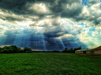 Scenic view of field against cloudy sky