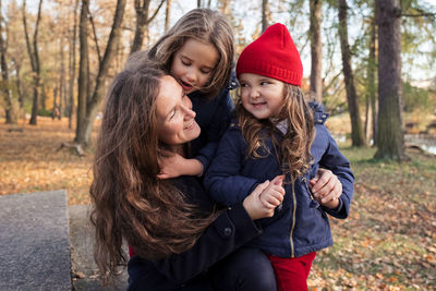 Happy woman with daughters in park