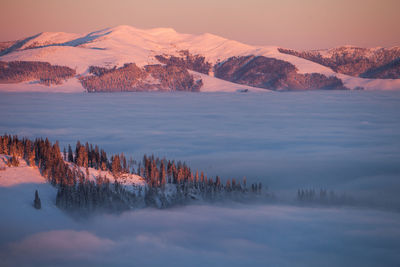 Scenic view of tree mountains against sky during sunset