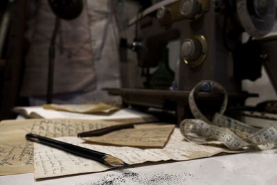 Close-up of old papers and pencil on table