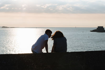 Rear view of couple looking at sea against sky